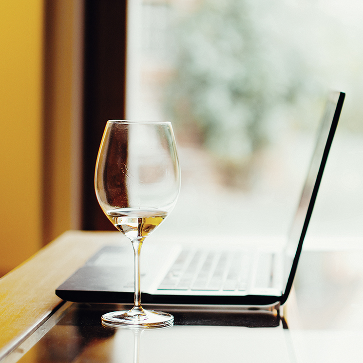 omslagsbild på en laptop och ett glas vin